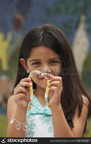 Portrait of a girl showing a candy necklace
