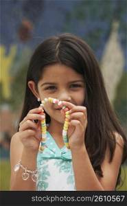 Portrait of a girl showing a candy necklace