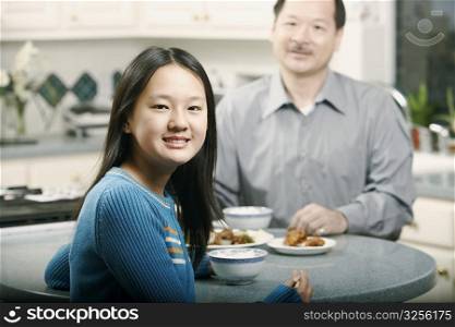 Portrait of a girl sitting at a table with her father