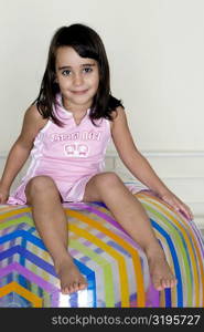 Portrait of a girl sitting on a large inflatable ball
