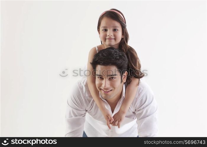 Portrait of a girl sitting on her father&rsquo;s back
