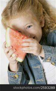 Portrait of a girl smiling and holding a slice of watermelon