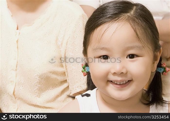 Portrait of a girl smiling with her grandmother beside her