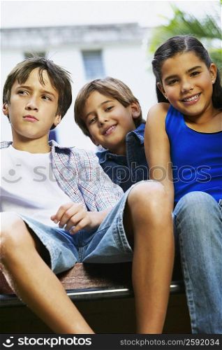 Portrait of a girl smiling with two boys