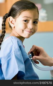 Portrait of a girl smirking while a doctor examining her