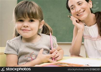 Portrait of a girl smirking with her teacher in the background