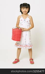 Portrait of a girl standing and holding a Chinese lantern