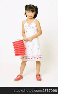 Portrait of a girl standing and holding a Chinese lantern