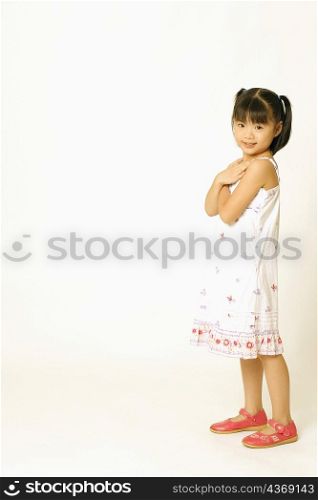 Portrait of a girl standing and hugging herself