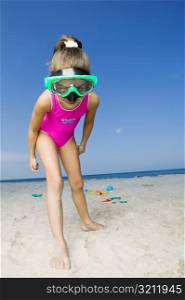 Portrait of a girl standing on the beach and wearing a scuba mask