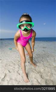 Portrait of a girl standing on the beach and wearing a scuba mask