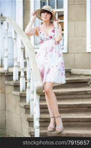 portrait of a girl standing on the stairs in sundress