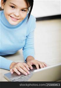 Portrait of a girl using a laptop and smiling