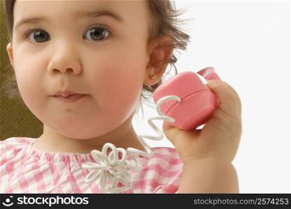 Portrait of a girl using a toy phone