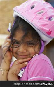 Portrait of a girl wearing a cycling helmet and smiling