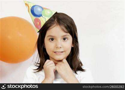 Portrait of a girl wearing a party hat and smiling