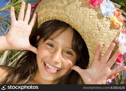 Portrait of a girl wearing a straw hat and sticking her tongue out