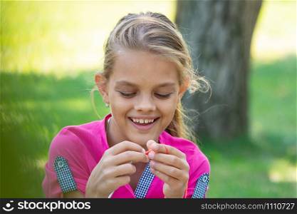 Portrait of a girl who knits on a knitting needles on a picnic in nature, close-up