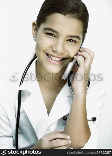Portrait of a girl with a stethoscope around her neck and talking on a mobile phone