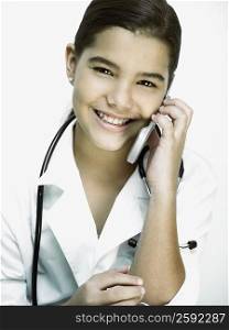 Portrait of a girl with a stethoscope around her neck and talking on a mobile phone