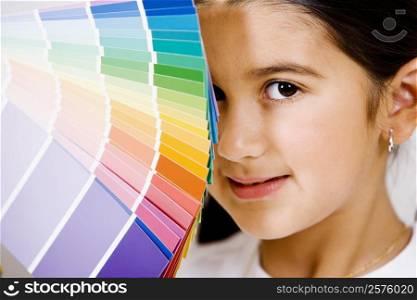 Portrait of a girl with color swatches in front of her face