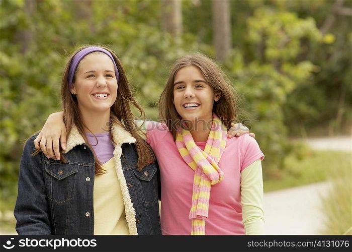 Portrait of a girl with her arm around her friend and smiling