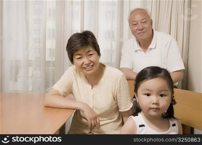 Portrait of a girl with her grandparents smiling behind her