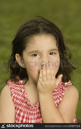 Portrait of a girl with her hand over her mouth