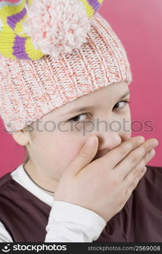 Portrait of a girl with her hands covering her mouth