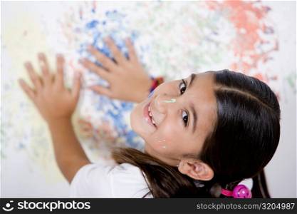 Portrait of a girl with her hands on a painted wall