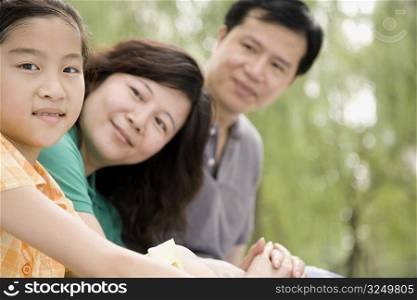 Portrait of a girl with her parents looking at her