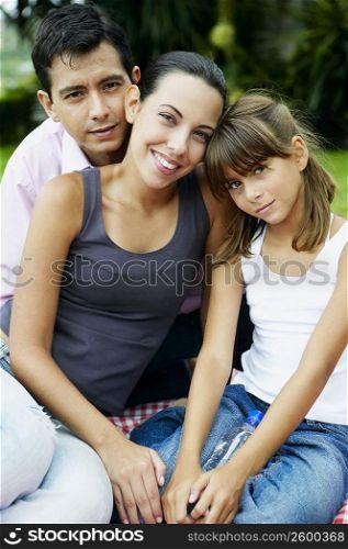Portrait of a girl with her parents sitting and smiling