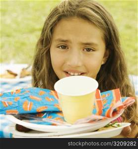 Portrait of a girl with plates and a disposable cup