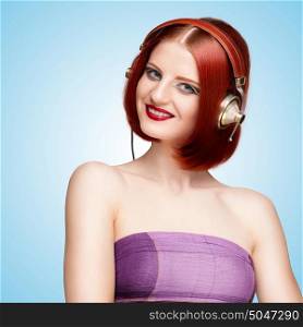 Portrait of a glamorous smiling girl, wearing metal vintage music headphones and listening to the retro music on blue background.
