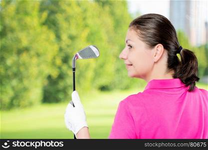 Portrait of a golfer with club and the space to the left on a background of golf courses