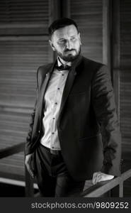 portrait of a groom with a beard in a blue suit and bow tie