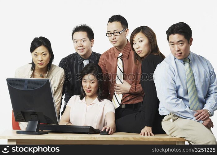 Portrait of a group of business executives in front of a computer