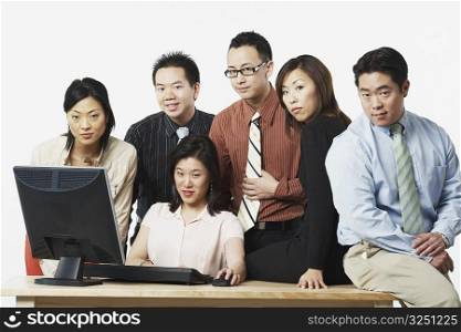 Portrait of a group of business executives in front of a computer