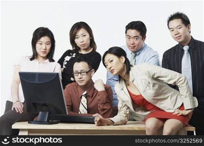 Portrait of a group of business executives in front of a computer