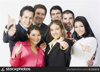 Portrait of a group of business executives making thumbs up signs and smiling