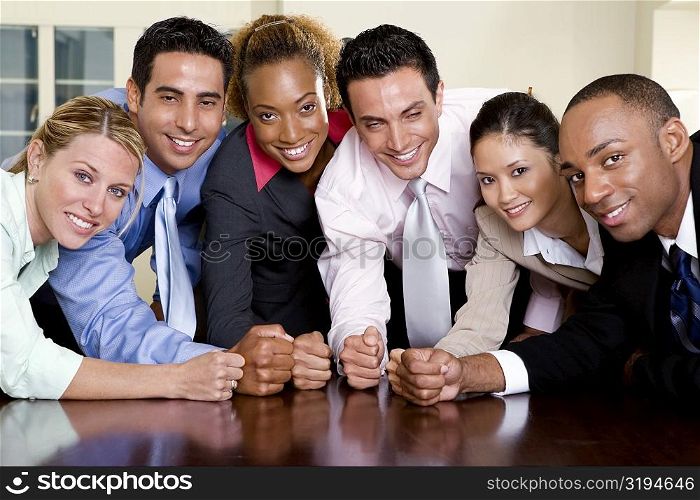 Portrait of a group of business executives with their fists on a table