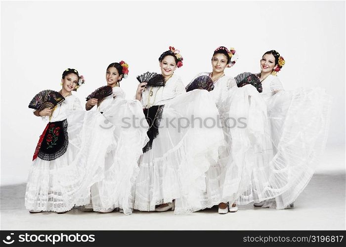 Portrait of a group of female dancers holding folding fans