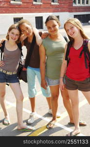 Portrait of a group of four young girls near school building