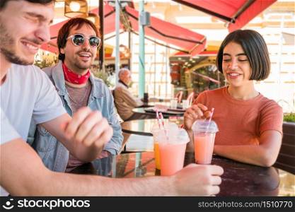 Portrait of a group of friends having fun together and enjoying good time while drinking fresh fruit juice at cafe. Lifestyle and friendship concept.