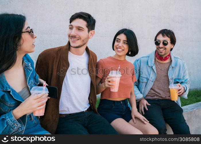 Portrait of a group of friends having fun together and enjoying good time while drinking fresh fruit juice. Lifestyle and friendship concept.