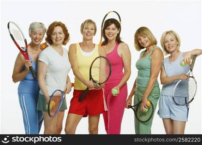 Portrait of a group of mature women holding tennis rackets and tennis balls