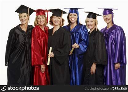 Portrait of a group of mature women wearing graduation gowns