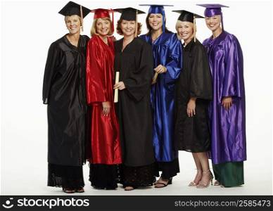 Portrait of a group of mature women wearing graduation gowns and standing together