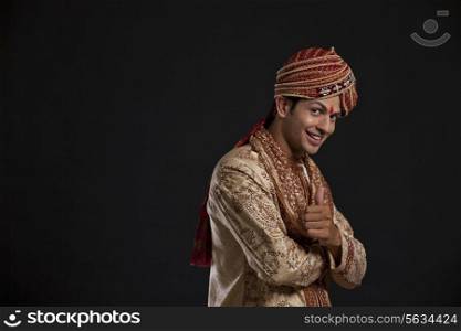 Portrait of a Gujarati groom giving the thumbs up