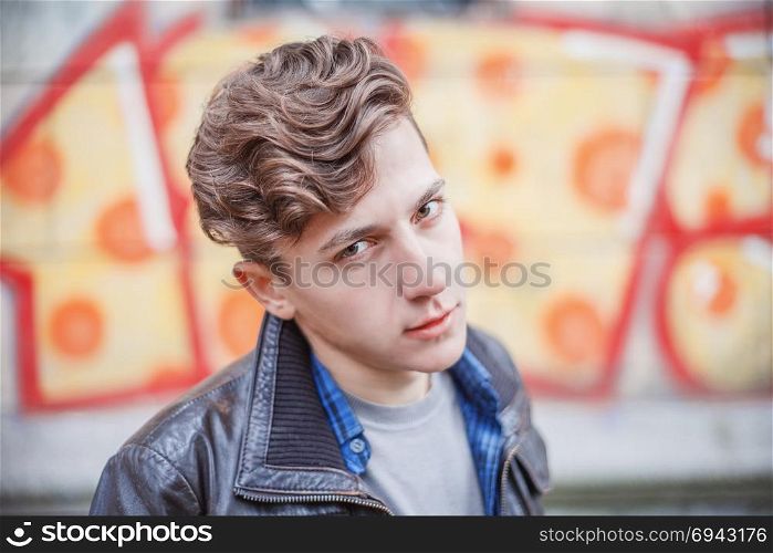 portrait of a guy in a leather jacket among the shabby walls